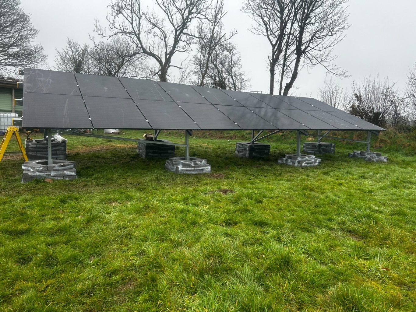 Solar panel system installed in an open field, capturing sunlight for renewable energy generation.