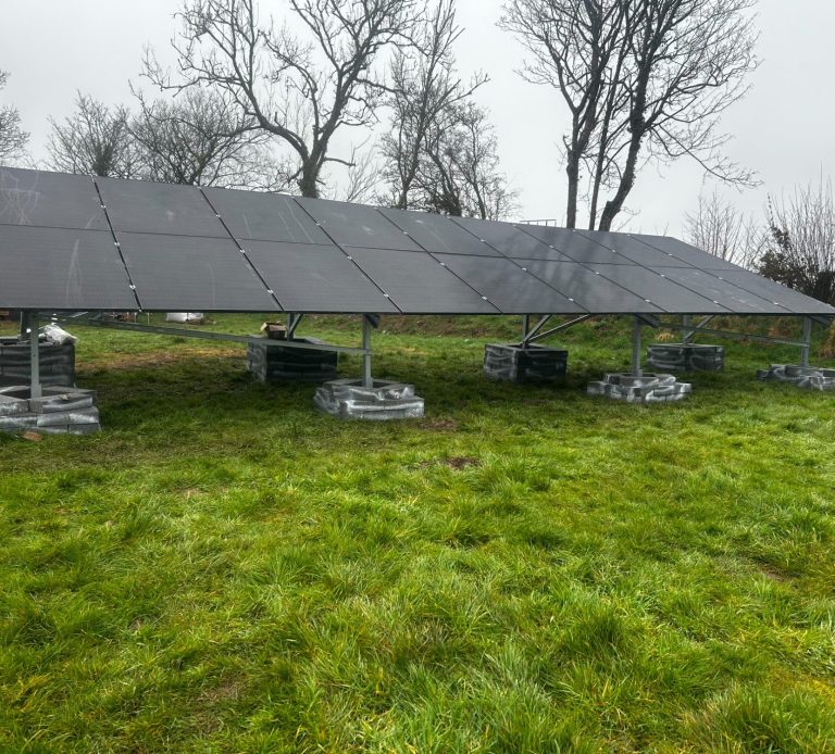 Solar panel system installed in an open field, capturing sunlight for renewable energy generation.