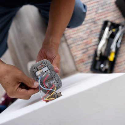 Electrician installing an electrical panel in a residential property.