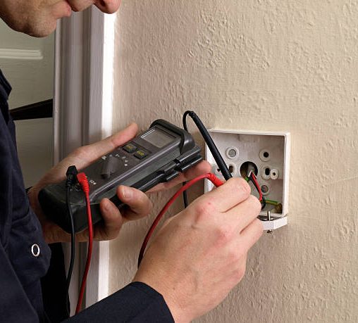 Electrician testing a socket for functionality and safety.