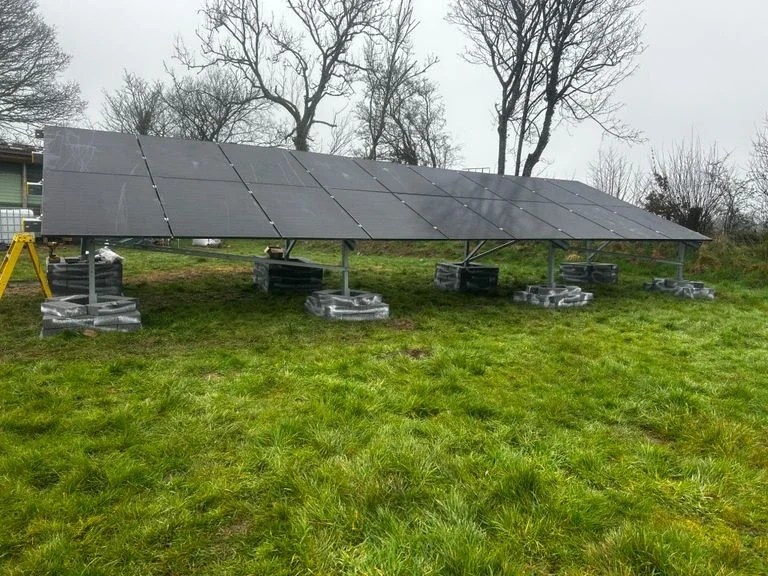 Solar panel system installed in an open field, capturing sunlight for renewable energy generation.